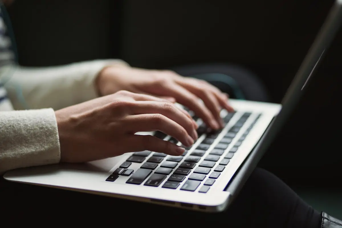 Seseorang menulis artikel di depan laptop